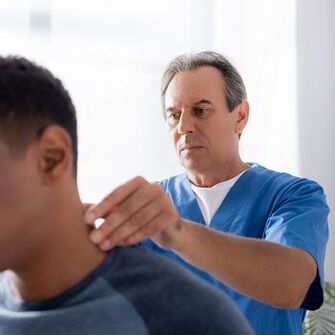 Doctor conducts diagnostic examination of patient with neck pain
